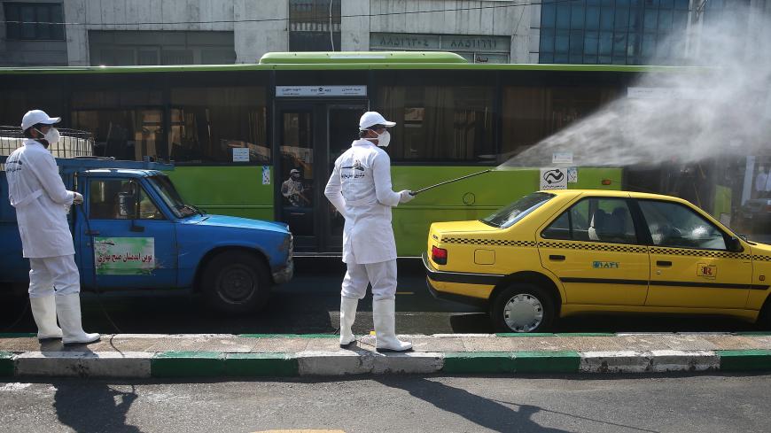 A member of the medical team wears protective face mask, following the coronavirus outbreak, as he sprays disinfectant liquid to sanitise a taxi car in Tehran, Iran March 05, 2020. WANA (West Asia News Agency)/Nazanin Tabatabaee via REUTERS ATTENTION EDITORS - THIS IMAGE HAS BEEN SUPPLIED BY A THIRD PARTY. - RC2MDF9X8TSF