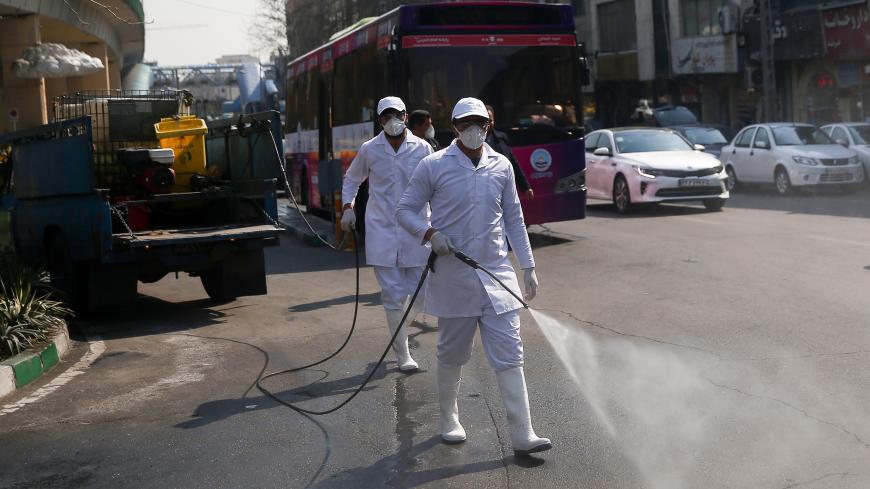 Members of the medical team wear protective face masks, following the coronavirus outbreak, as they spray disinfectant liquid to sanitise streets in Tehran, Iran March 05, 2020. WANA (West Asia News Agency)/Nazanin Tabatabaee via REUTERS ATTENTION EDITORS - THIS IMAGE HAS BEEN SUPPLIED BY A THIRD PARTY. - RC2MDF9LK5B6
