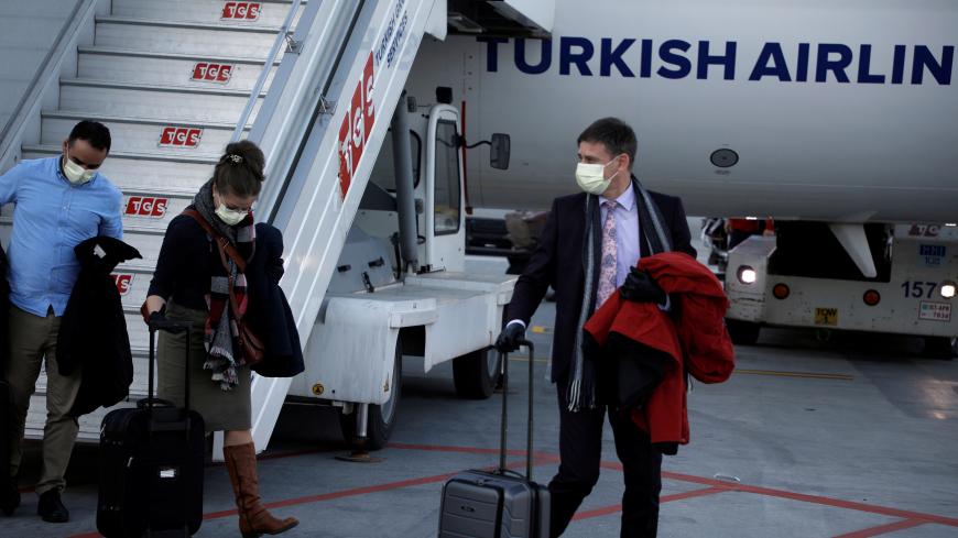 A passenger wears a protective face mask in light of the coronavirus, upon arrival at Istanbul Airport, Turkey, March 13, 2020. REUTERS/Florion Goga - RC28JF95WH9J