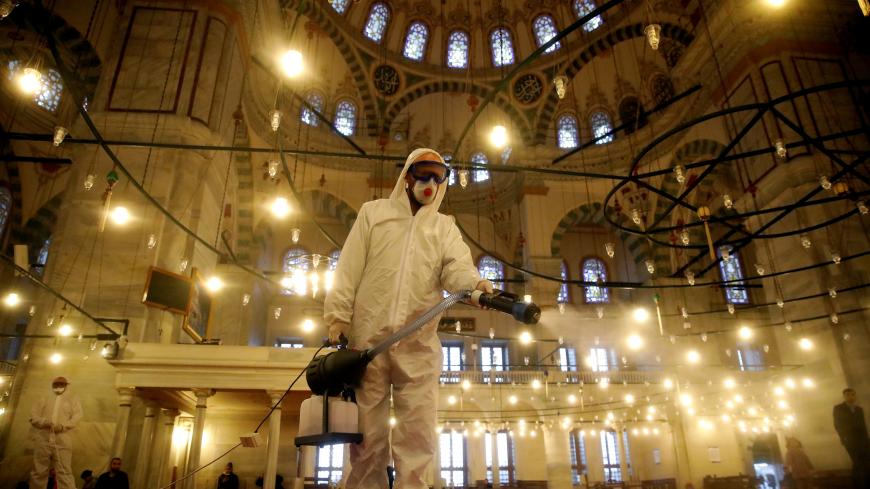 A worker in a protective suit disinfects the Fatih Mosque in Istanbul, Turkey March 14, 2020. REUTERS/Umit Bektas     TPX IMAGES OF THE DAY - RC2UJF9MI9KO