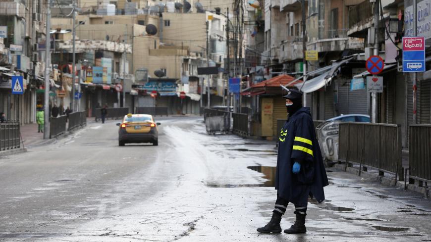A traffic police officer wearing a protective face mask stands on the street as the country takes measures to fight the spread of the coronavirus disease (COVID-19), in Amman, Jordan, March 18, 2020. REUTERS/Muhammad Hamed - RC2FMF9PF9CO