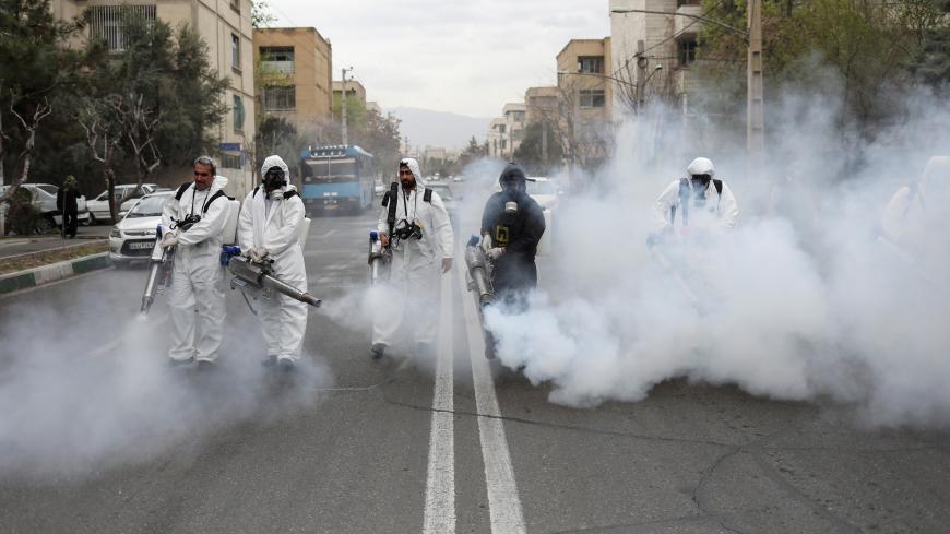 Members of firefighters wear protective face masks, amid fear of coronavirus disease (COVID-19), as they disinfect the streets, ahead of the Iranian New Year Nowruz, March 20, in Tehran, Iran March 18, 2020. Picture taken March 18, 2020. WANA (West Asia News Agency)/Ali Khara via REUTERS ATTENTION EDITORS - THIS PICTURE WAS PROVIDED BY A THIRD PARTY     TPX IMAGES OF THE DAY - RC23NF9FQH2G