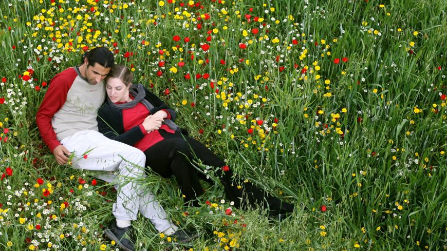 -PHOTO TAKEN 10APR06- Palestinian Muslim Osama Zatar, 26, spends some quiet time with his Israeli Jew wife, Jasmin Avissar, 25, near the West Bank village of Qarawat Bani Zeid near Ramallah, April 10, 2006. The couple's "Romeo and Juliet" struggle to live together is a rare tale of cross-border love in a land riven by years of [violence] between Israel and Palestinians. Picture taken April 10, 2006. - PBEAHUNNQCY