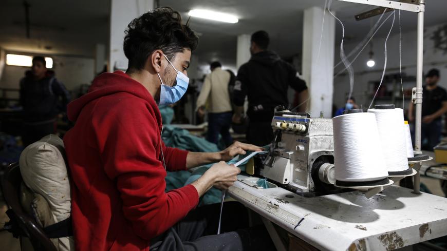 A palestinian worker manufacture protective coverall suits and masks at a workshop in Gaza City on March 31, 2020. amid coronavirus COVID-19 pandemic. Factories in the Gaza Strip used to specialize in the manufacture of shirts and jeans, for despite the closure of many of them in previous years due to the blockade imposed on the Gaza Strip and the inability to export and its aftermath From economic problems that led to the closure of many factories, But with the invasion of the new coronavirus to the world,