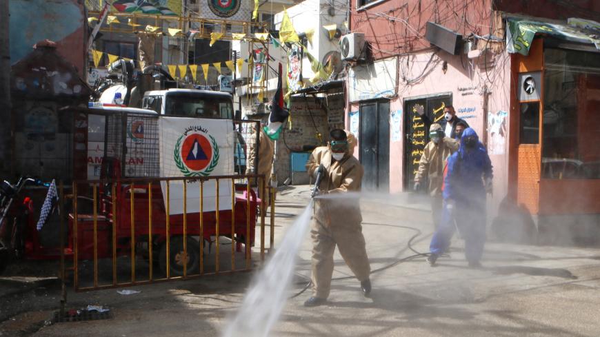 Workers disinfect the Wavel camp (also known as the Jalil Camp) for Palestinian refugees in Lebanon's eastern Bekaa Valley, on April 22, 2020, after the UN announced the first confirmed case of coronavirus there. - The patient, a Palestinian refugee from Syria, has been taken to the Lebanese state-run Rafiq Hariri hospital in Beirut, UNRWA, the UN agency for Palestinian refugees, said in a statement on April 21. More than 2,000 people live in Wavel, according to statistics released by Lebanons' government a