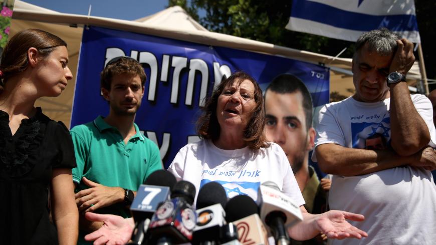Israeli Zehava Shaul, the mother of slain Israeli soldier Oron Shaul, who was killed in Gaza during the summer of 2014's 50-day military campaign against Hamas and body's has not been recovered, speaks during a press conference on June 29, 2016 next to her husband Herzel (R) at their protest tent outside the prime minister's residence in Jerusalem. 
Zur (L) and Ayelet Goldin whose brother Israeli army Lt. Hadar Goldin was also killed in Gaza and his body is believed to be held by Hamas, are also seen in the