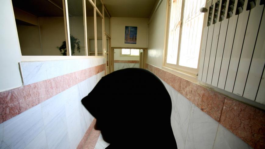 A female prison guard stands along a corridor in Tehran's Evin prison June 13, 2006. Iranian police detained 70 people at a demonstration in favour of women's rights, the judiciary said on Tuesday, adding it was ready to review reports that the police had beaten some demonstrators.  REUTERS/Morteza Nikoubazl (IRAN) - GM1DSVACQPAA