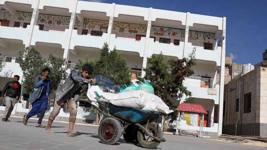 A worker pushes a wheel cart carrying food at a World Food Programme food aid distribution center in Sanaa, Yemen February 11, 2020. REUTERS/Khaled Abdullah - RC2GYE9WBNNR