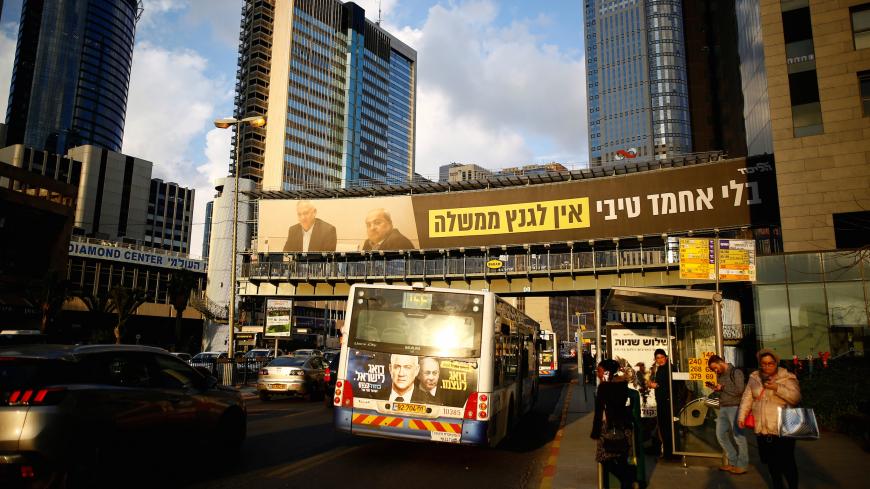 Israeli Prime Minister Benjamin Netanyahu's Likud party election campaign banner depicting his main rival Benny Gantz, head of Blue and White party sitting with Arab politician Ahmad Tibi, of the Joint List party, and Hebrew writing reading: "Without Ahmad Tibi, Gantz doesn't have a government", is seen in Ramat Gan, near Tel Aviv, Israel, February 25, 2020. Picture taken February 25, 2020. REUTERS/Corinna Kern - RC2F8F9OG6H9