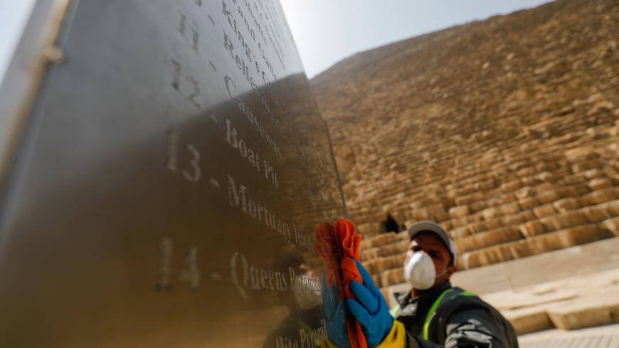 A member of the medical team sprays disinfectant as a precautionary move amid concerns over the coronavirus disease (COVID-19) outbreak at the Great Pyramids, Giza, on the outskirts of Cairo, Egypt, March 25, 2020. REUTERS/Amr Abdallah Dalsh - RC2XQF9EVLPF