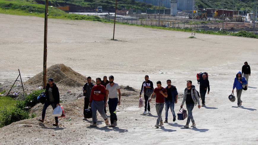 Palestinian workers returning from Israel arrive at a testing site for the coronavirus disease (COVID-19), outside the Israeli-controlled Tarqumiya checkpoint near Hebron in the Israeli-occupied West Bank March 26, 2020. REUTERS/Mussa Qawasma - RC2RRF9ZN4LX