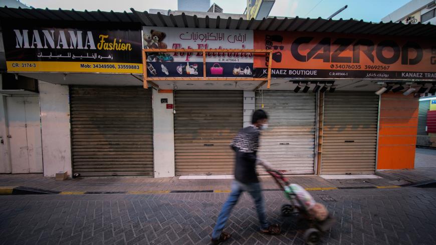 A man walks past closed shops, as government's restrictions were introduced following the outbreak of coronavirus disease (COVID-19), in Manama, Bahrain, March 26, 2020. REUTERS/Hamad I Mohammed - RC2URF9WS1OP