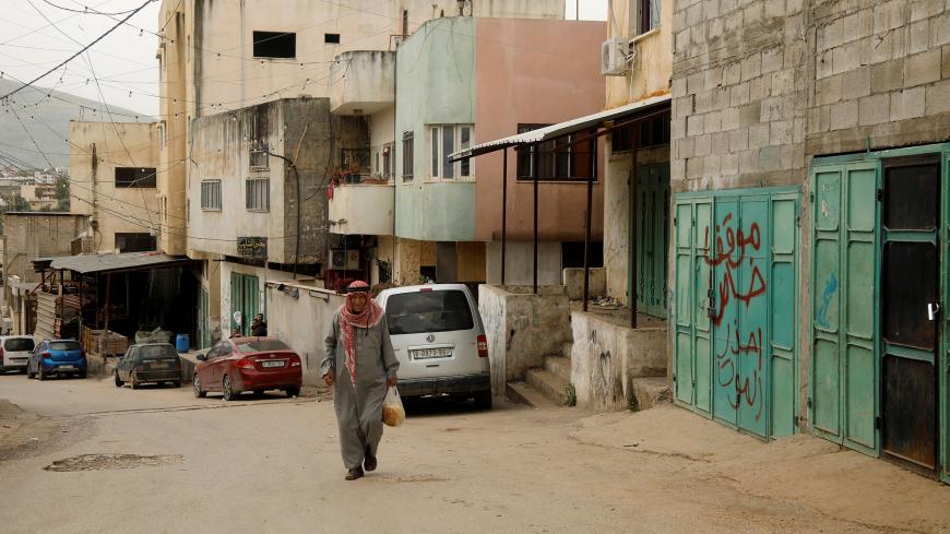 A Palestinian man walks in al-Fari'ah refugee camp amid concerns about the spread of the coronavirus disease (COVID-19), in the Israeli-occupied West Bank March 31, 2020. Picture taken March 31, 2020. REUTERS/Raneen Sawafta - RC29WF9H3Y8K