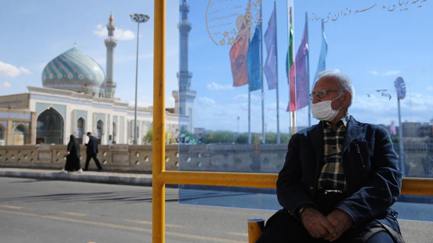 A man wearing a protective face mask, following the outbreak of coronavirus disease (COVID-19), sits at a bus stop in Qom, Iran March 24, 2020. Picture taken March 24, 2020. WANA (West Asia News Agency) via REUTERS ATTENTION EDITORS - THIS PICTURE WAS PROVIDED BY A THIRD PARTY - RC2BWF9JVDZM