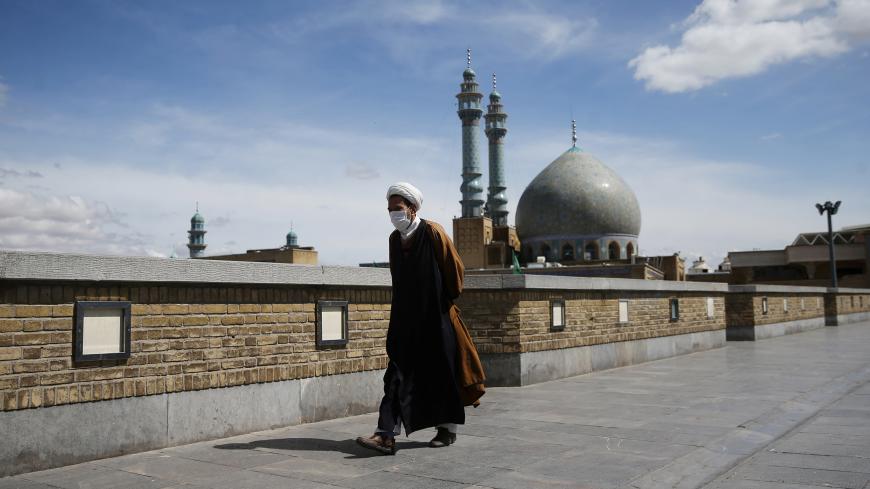 A cleric wearing a protective face mask, following the outbreak of coronavirus disease (COVID-19), walks on the street in Qom, Iran March 24, 2020. Picture taken March 24, 2020. WANA (West Asia News Agency) via REUTERS ATTENTION EDITORS - THIS PICTURE WAS PROVIDED BY A THIRD PARTY - RC2BWF9C9CN1