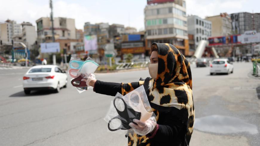 A woman wears a protective face mask and gloves, amid fear of the coronavirus disease (COVID-19), as she sells the masks in Tajrish square in Tehran, Iran April 2, 2020. WANA (West Asia News Agency)/Ali Khara via REUTERS ATTENTION EDITORS - THIS PICTURE WAS PROVIDED BY A THIRD PARTY - RC2DWF9I0AKY