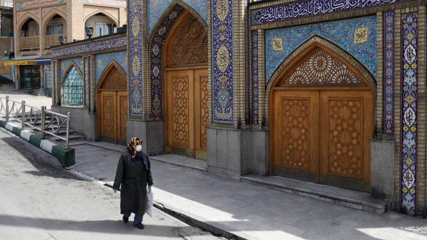 A woman wearing a protective face mask and gloves walks past the Imamzadeh Saleh shrine, amid fear of the coronavirus disease (COVID-19), in Tehran, Iran April 2, 2020. WANA (West Asia News Agency)/Ali Khara via REUTERS ATTENTION EDITORS - THIS PICTURE WAS PROVIDED BY A THIRD PARTY - RC2DWF9GIRD0