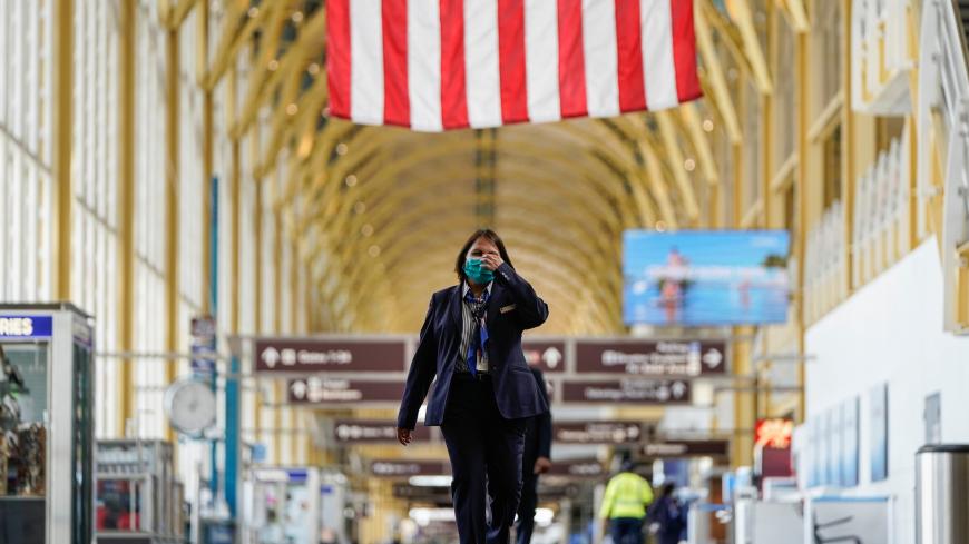 An airline employee walks through Reagan National Airport during the coronavirus disease (COVID-19) outbreak in Washington, U.S., April 5, 2020.      REUTERS/Joshua Roberts - RC2KYF955PLJ