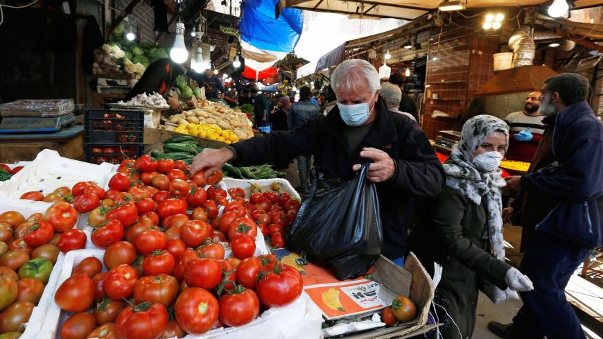 A man wears a face mask amid concerns over the coronavirus disease (COVID-19) as he buys vegetables in Amman, Jordan,  April 12, 2020. REUTERS/Muhammad Hamed - RC223G9UB4B9