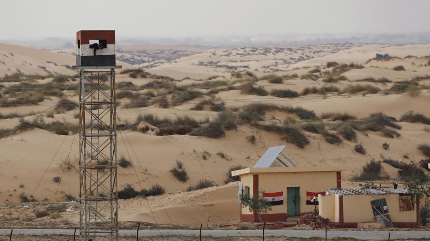 An Egyptian policeman gestures from an observation tower is seen from the Israeli side of the border with Egypt's Sinai peninsula, in Israel's Negev Desert February 10, 2016. REUTERS/Amir Cohen  - GF10000303487
