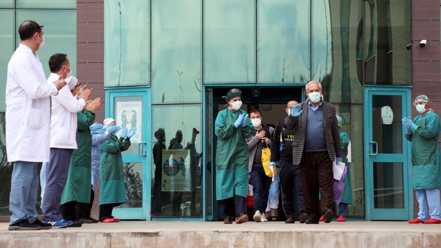 Medical staff members applaud patients who are leaving from the Dicle University Hospital after recovering from the coronavirus disease (COVID-19), in Diyarbakir, Turkey, April 15, 2020. REUTERS/Sertac Kayar - RC235G92Y92U