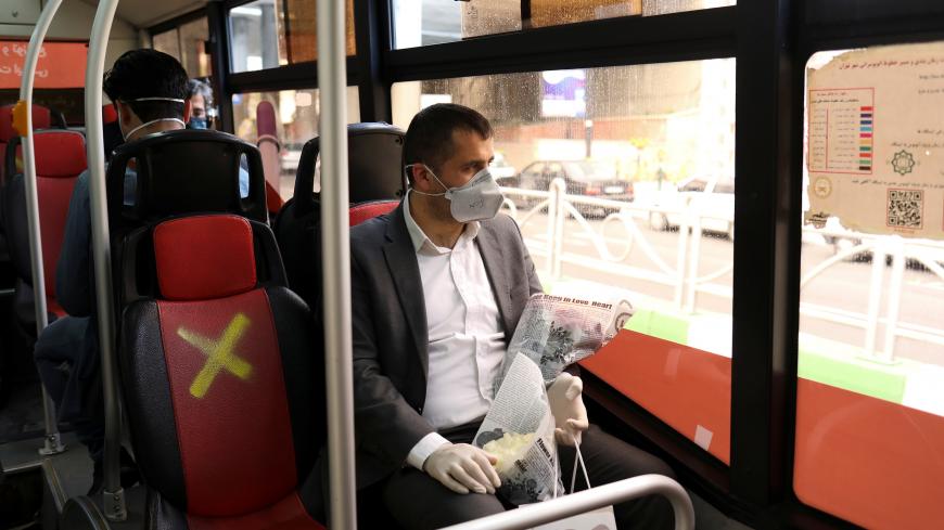 A man wears a protective face mask as he sits in a bus, following the outbreak of the coronavirus disease (COVID-19), after shopping malls and bazaars reopened in Tehran, Iran, April 20, 2020. WANA (West Asia News Agency)/Ali Khara via REUTERS ATTENTION EDITORS - THIS PICTURE WAS PROVIDED BY A THIRD PARTY - RC2F8G9K61IV