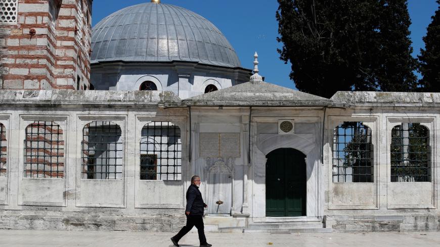 A man walks past closed for prayers Suleymaniye Mosque during the first day of Ramadan and the second of a four-day curfew, as the spread of the coronavirus disease (COVID-19) continues, in Istanbul, Turkey April 24, 2020. REUTERS/Umit Bektas - RC20BG9OLAZD