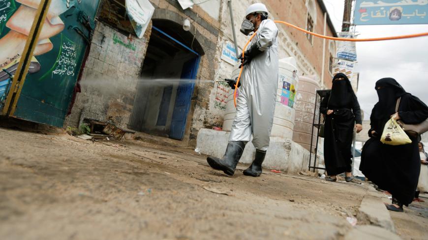 A health worker wearing a protective suit disinfects a market amid concerns of the spread of the coronavirus disease (COVID-19), in Sanaa, Yemen April 28, 2020. REUTERS/Khaled Abdullah - RC2RDG964XER