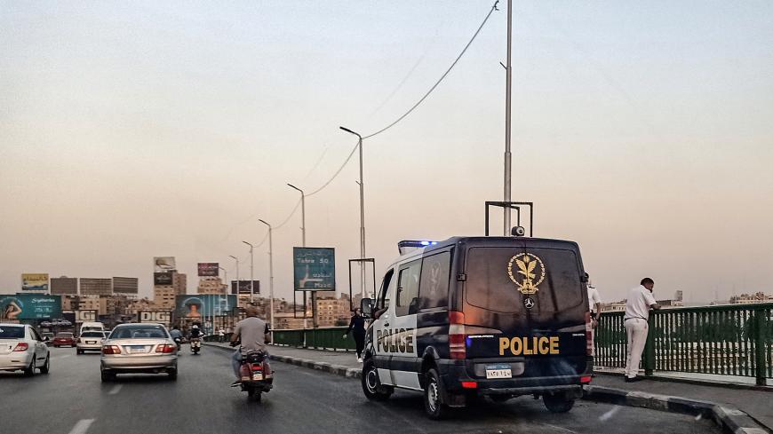 Policemen stand next to a patrol car parked along the 6th of October bridge crossing the Nile in the centre of the Egyptian capital Cairo on September 21, 2019. - Protests erupted late on September 20 in Cairo and other Egyptian cities calling for the removal of President Abdel Fattah al-Sisi, in a rare show of dissent quickly quashed by authorities. After overnight clashes with the protesters, security forces the following day maintained tight control of Tahrir Square -- the epicentre of the 2011 revolutio