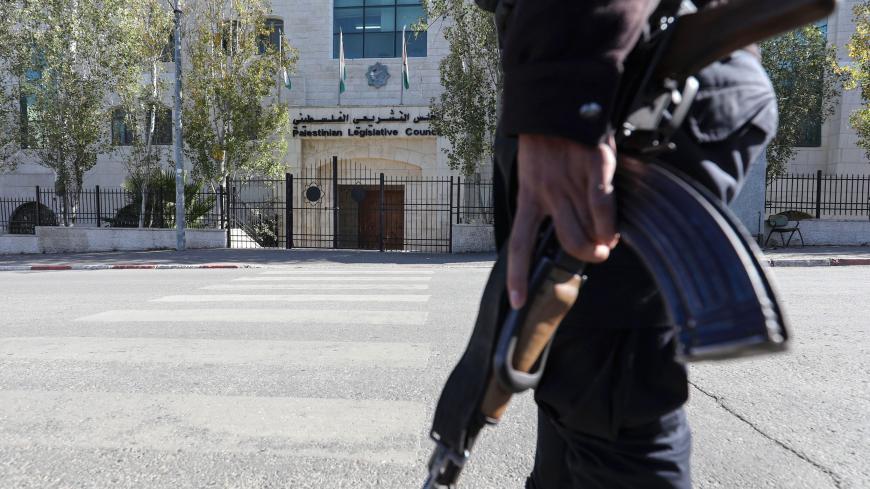 Palestinian police stand guard near the main door of the defunct Palestinian Parliament in the West Bank city of Ramallah on December 17, 2019. - It has been more than a decade since the Palestinian Legislative Council (PLC) last met in Ramallah, due to infighting between Palestinian president Mahmud Abbas's Fatah and Islamists Hamas. The shiny new parliament building was opened in 2004 in central Ramallah, the Palestinian city in the occupied West Bank 10 miles (16 kilometres) north of Jerusalem. Construct