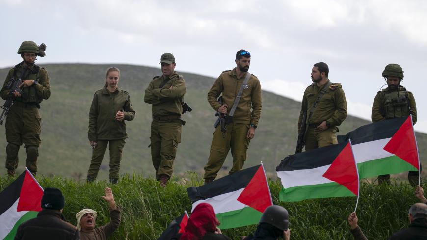 Israeli soldiers stand at attention as Palestinian demonstrators take part in a protest against the annexation of the Jordan Valley, in the village of Tammun, east of West Bank village of Tubas, near the Jordan Valley, on February 29, 2020. (Photo by JAAFAR ASHTIYEH / AFP) (Photo by JAAFAR ASHTIYEH/AFP via Getty Images)