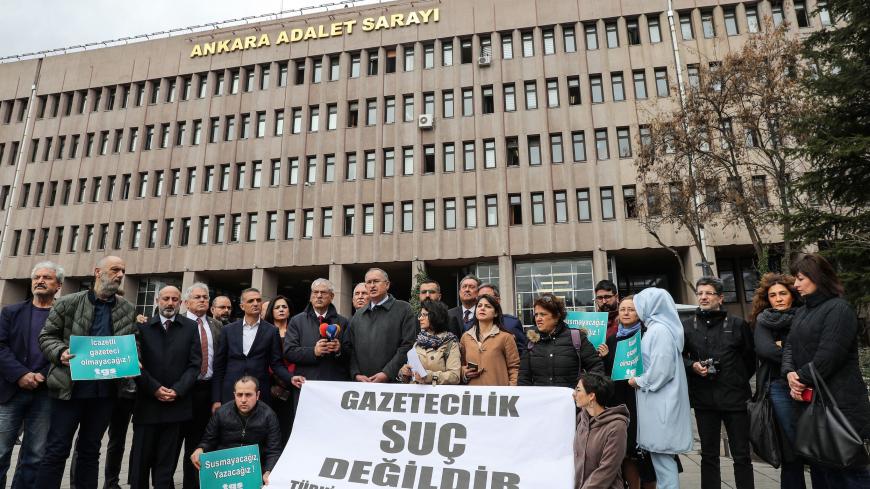 Journalists gather outside the Ankara courthouse on March 10, 2020 behind a banner reading in Turkish "journalism is not crime," to protest over jailing of journalists, sparked by the recent arrest of OdaTV's news director and a journalist's report on the funeral of a Turkish intelligence officer apparently killed in Libya. - The journalists were taken to an Istanbul court formally arrested them on suspicion of disclosing the identity of an intelligence agency official. RSF ranks Turkey 157th out of 180 cou