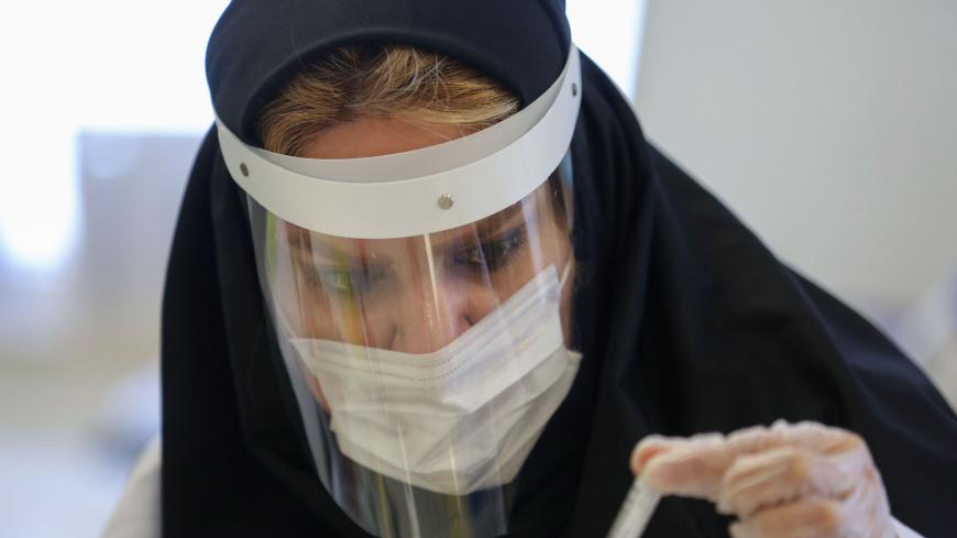 TOPSHOT - An Iranian doctor works on the production of COVID-19 test kits at a medical center in Karaj, in the northern Alborz Province, on April 11, 2020. - Iran reported 125 new deaths from the novel coronavirus, raising the overall toll in the Middle East's worst-hit country to 4,357. (Photo by ATTA KENARE / AFP) (Photo by ATTA KENARE/AFP via Getty Images)