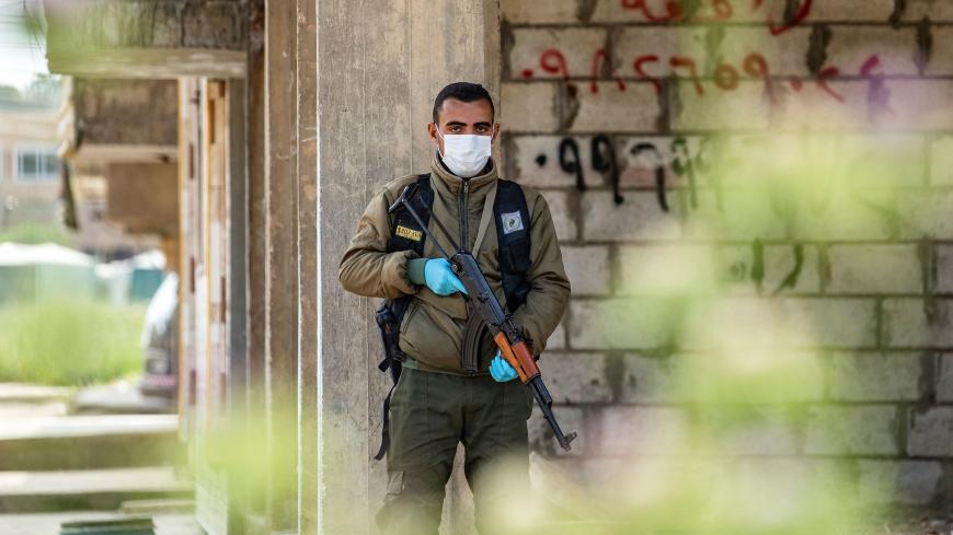 A member of the Kurdish Internal Security Forces of Asayesh stands guard on a deserted street in Syria's northeastern city of Hasakeh on April 30, 2020, following measures taken by the Kurdish-led local authorities there, to limit the spread of the novel coronavirus. (Photo by DELIL SOULEIMAN / AFP) (Photo by DELIL SOULEIMAN/AFP via Getty Images)
