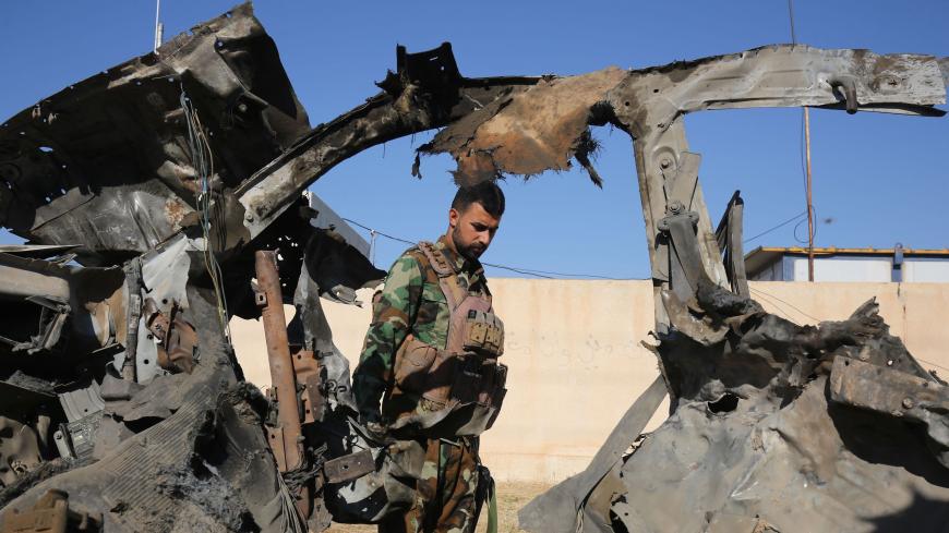 An Iraqi fighter with the Hashed al-Shaabi (Popular Mobilisation Forces) inspects the site of the Islamic State (IS) group attack, a day earlier, on a unit of the paramilitary force in Mukaishefah, about 180km (110 miles) north of the capital, on May 3, 2020. - IS group remnants in Iraq are exploiting a coronavirus lockdown, coalition troop withdrawals and simmering political disputes to ramp up deadly attacks, according to analysts and intelligence officials, the bloodiest so far being an ambush early on M