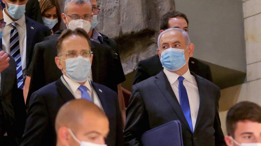Israeli Prime Minister Benjamin Netanyahu (R), wearing a protective face mask, arrives for the swearing-in ceremony at Israel's parliament, the Knesset, in Jerusalem on May 17, 2020 - As Israel was set to launch its new unity government Sunday, Prime Minister Benjamin Netanyahu vowed to push on with controversial plans to annex large parts of the occupied West Bank. (Photo by Alex KOLOMIENSKY / POOL / AFP) (Photo by ALEX KOLOMIENSKY/POOL/AFP via Getty Images)