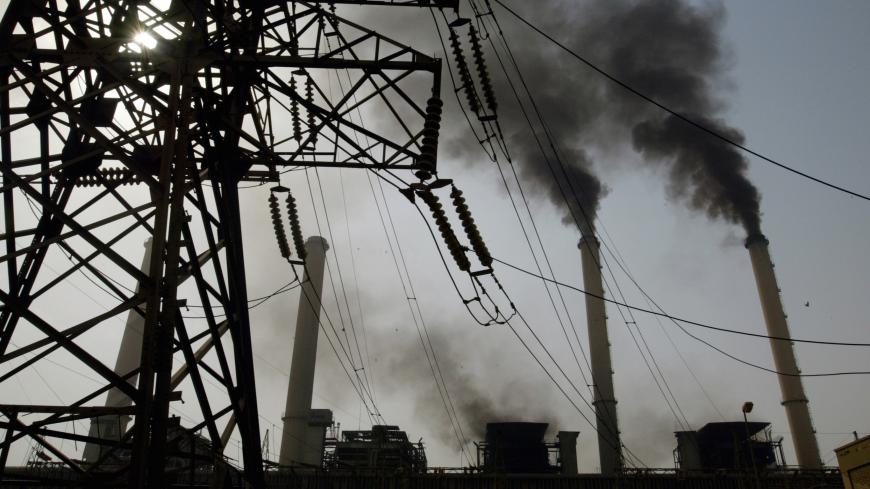 BAGHDAD, IRAQ -OCTOBER 11:  Black smoke pours out of the smoke stacks at the Al-Doura power plant in Baghdad, October 11, 2003. The outdated power grid damaged in the war and in months of sabotage is working at 25% of its capacity. Restoring electricity is costing of $5.7 billion , the biggest price tag in the Iraq reconstruction.  (Photo by Paula Bronstein/Getty Images)