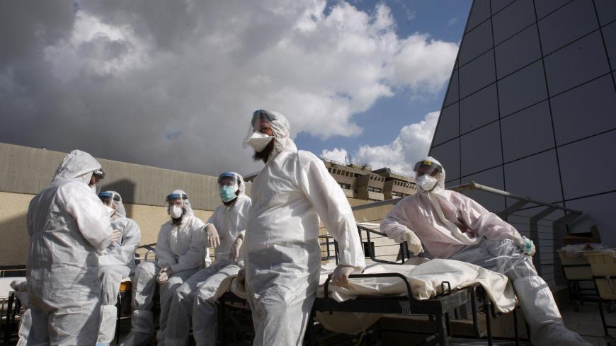Medical workers wait for mock victims to arrive by ambulance to Chaim Sheba Medical Center near Tel Aviv during a drill simulating a biological attack January 13, 2010. REUTERS/Gil Cohen Magen (ISRAEL - Tags: HEALTH) - GM1E61D1ME901