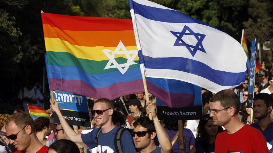 Participants hold flags during the gay pride parade in Jerusalem July 29, 2010. This year's parade marks the one-year anniversary of a shooting attack in a gay and lesbian youth center in Tel Aviv, in which two people were killed and 13 were injured. REUTERS/Ronen Zvulun (JERUSALEM - Tags: POLITICS SOCIETY) - GM1E67U04VD01