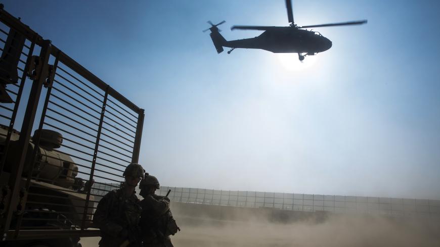 U.S. soldiers from the 3rd Cavalry Regiment cover their faces as a Blackhawk helicopter takes off during a mission for Brigadier General Christopher Bentley to inspect an Afghan National police installation in the Nangarhar province of Afghanistan December 16, 2014. REUTERS/Lucas Jackson (AFGHANISTAN - Tags: CIVIL UNREST POLITICS MILITARY TPX IMAGES OF THE DAY) - GM1EACG1TN401