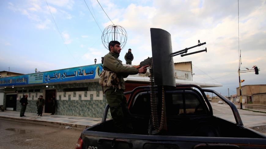 A fighter of Syrian Democratic Forces (SDF) stands on the back of a pick-up truck, with a weapon installed on it, in Qamishli, Syria March 30, 2019. Picture taken March 30, 2019. REUTERS/Ali Hashisho - RC1961AA5550