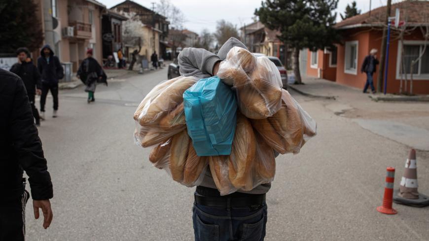 A migrant carries breads he bought in a shop in Karaagac district near Turkey's Pazarkule border crossing with Greece's Kastanies, in Edirne, Turkey, March 10, 2020. REUTERS/Marko Djurica - RC21HF9CFTXY