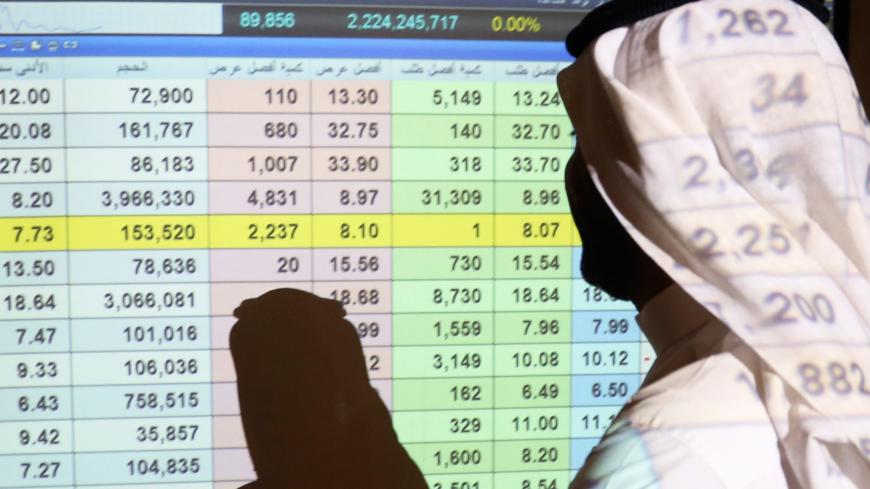 A Saudi man stands in front of a screen of stock prices at ANB Bank in Riyadh, Saudi Arabia March 15, 2020. REUTERS/Ahmed Yosri - RC2AKF95RT3F