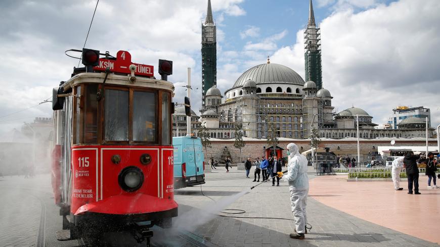 A municipality worker sprays disinfectant over a tram to prevent the spread of coronavirus disease (COVID-19) in central Istanbul, Turkey, March 18, 2020. REUTERS/Kemal Aslan - RC2DMF9Q7YSE