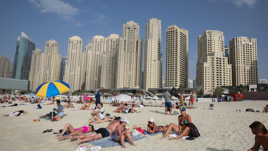 People are seen on Jumeirah Beach residence, following the outbreak of coronavirus disease (COVID-19), in Dubai, United Arab Emirates, March 19, 2020. REUTERS/Christopher Pike - RC24NF9KLRML