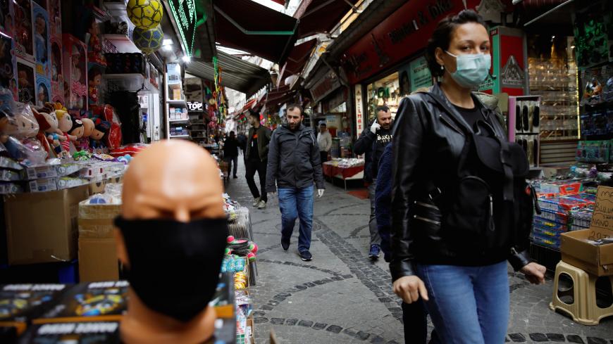 A woman wearing a protective face mask walks in a market at Eminonu neighbourhood during the outbreak of coronavirus disease (COVID-19), in Istanbul, Turkey, March 23, 2020. REUTERS/Umit Bektas - RC2MPF9PPR1K