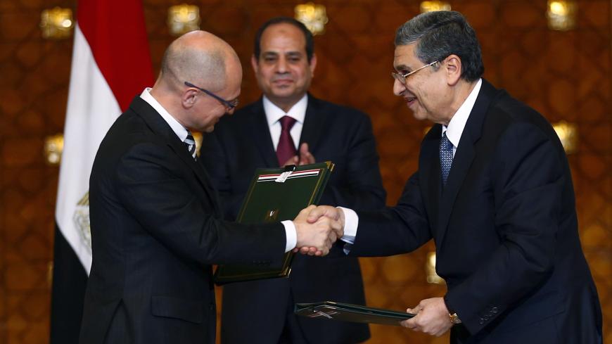 Egypt's President Abdel Fattah al-Sisi (C) looks on as Chief Executive Officer of Russian Rosatom company Sergey Kiriyenko (L) and Egyptian Minister of Electricity and Renewable Energy Mohamed Shaker (R) shakes hand after signing documents for a deal to build Egypt's first nuclear power plant at the Ittihadiya presidential palace in Cairo, Egypt, November 19, 2015. Moscow and Cairo signed an agreement on Thursday for Russia to build a nuclear power plant in Egypt, with Russia extending a loan to Egypt to co