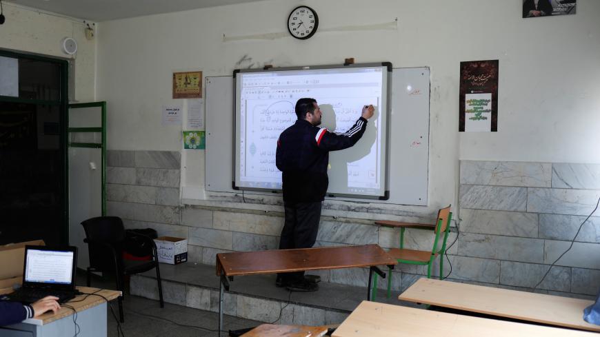 An Arabic language teacher writes on a board while teaching online school classes to students at their homes, as schools are still closed, following the outbreak of the coronavirus disease (COVID-19), in Tehran, Iran April 15, 2020. WANA (West Asia News Agency)/Ali Khara via REUTERS ATTENTION EDITORS - THIS PICTURE WAS PROVIDED BY A THIRD PARTY - RC245G94BCPK