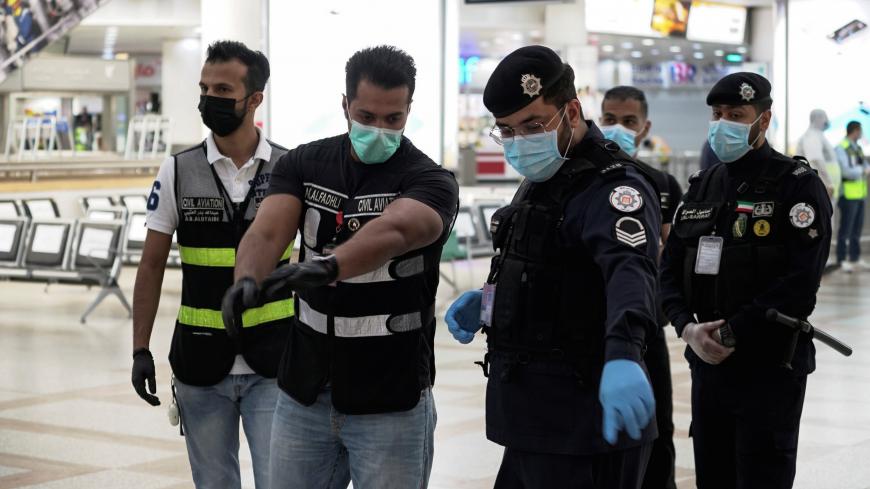 Police and civil aviation personnel wearing protective face masks work at the Kuwait Airport as the repatriation process of Kuwait citizens continues, following the outbreak of the coronavirus disease (COVID-19), in Kuwait City, Kuwait April 21, 2020. REUTERS/Stephanie McGehee - RC229G938E9I