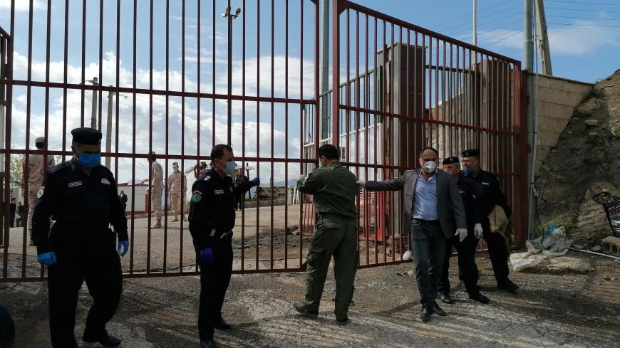 Iraqi Kurdish officers and policemen stand at the gate of the border between Iraqi Kurdistan and Iran, that partially reopened for the first time since the outbreak of the coronavirus disease (COVID-19), at the border between Iran and Iraqi Kurdistan in Halabja Province, Iraq May 3, 2020. REUTERS/Saman Mahmood - RC24HG9M4JY9
